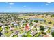 Aerial view showcasing a home in a neighborhood, golf course, water, and lush greenery at 2167 Kerwood Loop, The Villages, FL 32162