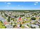 Wide aerial shot shows the home in a developed neighborhood with tree-lined streets at 2167 Kerwood Loop, The Villages, FL 32162