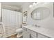 Bright bathroom with white vanity, brushed nickel hardware, shower with curtain and bright natural light at 2167 Kerwood Loop, The Villages, FL 32162