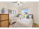 Bright bedroom featuring two twin beds, a ceiling fan, and a window with a view of the outdoors at 2167 Kerwood Loop, The Villages, FL 32162