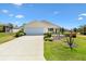 Inviting single-story home with well-manicured lawn, an attached garage, and a charming front porch at 2167 Kerwood Loop, The Villages, FL 32162
