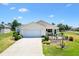 Inviting single-story home featuring a well-maintained lawn and driveway with an attached garage at 2167 Kerwood Loop, The Villages, FL 32162