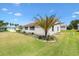 Well-kept home featuring a green lawn, meticulous landscaping, and mature palm trees for curb appeal at 2167 Kerwood Loop, The Villages, FL 32162