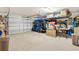 Spacious garage with ample room for storage, a golf cart, and an automatic garage door at 2167 Kerwood Loop, The Villages, FL 32162