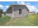 Backyard featuring a lush green lawn and pristine vinyl siding on a sunny day at 2296 Whisper St, The Villages, FL 32162
