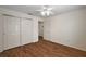 Bedroom with hardwood floors, a ceiling fan, and a closet for plenty of storage space at 2296 Whisper St, The Villages, FL 32162