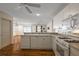 Bright open kitchen with white cabinetry, modern appliances and hardwood floors at 2296 Whisper St, The Villages, FL 32162