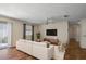 Bright living room with a white sofa, ceiling fan, and a large window bringing in natural light at 2296 Whisper St, The Villages, FL 32162