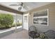 Enclosed lanai area with a fan, outdoor seating with view of the beautiful landscaping at 2296 Whisper St, The Villages, FL 32162