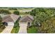 Aerial view of a charming single-story home with well-manicured lawn and stunning water views at 24346 Amberleaf Ct, Leesburg, FL 34748