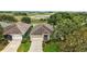 Aerial view of a charming single-story home with well-manicured lawn and stunning water views at 24346 Amberleaf Ct, Leesburg, FL 34748