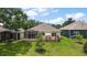 Beautiful backyard featuring a screened lanai, patio with umbrella, and lush green lawn at 24346 Amberleaf Ct, Leesburg, FL 34748