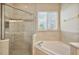 Bright bathroom featuring separate shower and soaking tub with natural light at 24346 Amberleaf Ct, Leesburg, FL 34748