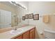 Standard bathroom featuring a single sink vanity, neutral walls, and framed artwork at 24346 Amberleaf Ct, Leesburg, FL 34748