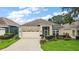 Well-maintained single-story home with a two-car garage, lush landscaping, and a welcoming entrance at 24346 Amberleaf Ct, Leesburg, FL 34748
