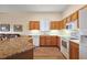 Bright kitchen featuring white appliances, light wood cabinets and granite countertops adding a touch of elegance at 24346 Amberleaf Ct, Leesburg, FL 34748