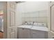 Laundry room showcasing a white washer and dryer with wire shelving above at 24346 Amberleaf Ct, Leesburg, FL 34748