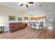 Cozy living room featuring a large leather sofa, hardwood floors, and an open layout to kitchen, perfect for entertaining at 24346 Amberleaf Ct, Leesburg, FL 34748