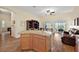 Bright living area featuring an island and a living room with a leather sofa and a beautiful view at 24346 Amberleaf Ct, Leesburg, FL 34748