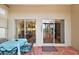 Relaxing patio with a dining set and views of the home's interior and landscaping at 24346 Amberleaf Ct, Leesburg, FL 34748