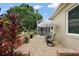 Back patio featuring an umbrella and table set, overlooking a serene yard and screened in lanai at 24346 Amberleaf Ct, Leesburg, FL 34748