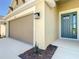Close-up view of home features an attached two-car garage, stylish door, and a coach lamp at 2675 Ridgetop Ln, Clermont, FL 34711