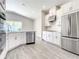Bright kitchen featuring stainless steel appliances, white cabinetry, and tile flooring at 2675 Ridgetop Ln, Clermont, FL 34711