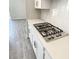 Modern kitchen featuring a stainless steel cooktop and white quartz countertops at 2675 Ridgetop Ln, Clermont, FL 34711