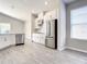 Modern kitchen with white cabinets, stainless steel appliances, and wood-look flooring at 2675 Ridgetop Ln, Clermont, FL 34711