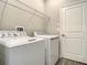 Clean laundry room with a full-size washer and dryer and overhead shelving at 2675 Ridgetop Ln, Clermont, FL 34711
