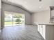 Bright living room with wood-look tile, backyard view, and modern design at 2675 Ridgetop Ln, Clermont, FL 34711