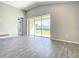 Bright living room with sliding glass doors, wood-look tile flooring, and neutral paint at 2675 Ridgetop Ln, Clermont, FL 34711