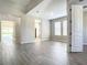 Open living room featuring wood-look tile flooring, neutral paint, and abundant natural light at 2675 Ridgetop Ln, Clermont, FL 34711