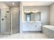 Modern bathroom features a glass enclosed shower, soaker tub, and dual sink vanity with framed mirrors at 2675 Ridgetop Ln, Clermont, FL 34711