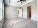 Comfortable carpeted bedroom featuring a ceiling fan, neutral color palette, and access to the bathroom at 2675 Ridgetop Ln, Clermont, FL 34711