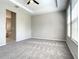 Carpeted primary bedroom with a tray ceiling, base molding and view to the ensuite bathroom at 2675 Ridgetop Ln, Clermont, FL 34711