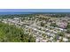 An aerial view showcases a serene community near the water and green spaces, with trees and well-maintained homes at 3026 Myakka River Rd, Tavares, FL 32778