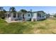 Back exterior view with patio and lawn at 3026 Myakka River Rd, Tavares, FL 32778
