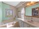 Bathroom featuring a bathtub, a single sink vanity, and decorative wallpaper at 3026 Myakka River Rd, Tavares, FL 32778
