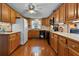 Well-appointed kitchen with wood cabinets, appliances, a tiled backsplash and hardwood floors at 3026 Myakka River Rd, Tavares, FL 32778