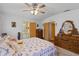 Relaxing main bedroom featuring a floral comforter, wood furniture, and an attached bathroom at 3026 Myakka River Rd, Tavares, FL 32778