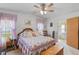 Charming main bedroom with a floral comforter, wood accents, and a comfortable chair at 3026 Myakka River Rd, Tavares, FL 32778