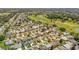 Expansive aerial view of a residential community adjacent to a lush golf course and water feature at 3041 Batally Ct, The Villages, FL 32162