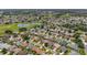 Aerial view showcases a neighborhood adjacent to a lush golf course and a tranquil lake at 3041 Batally Ct, The Villages, FL 32162