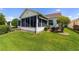 Backyard showing the home's screened-in porch and well-maintained lawn at 3041 Batally Ct, The Villages, FL 32162
