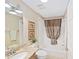 Bathroom featuring a granite countertop, decorative mirror, and shower-tub combination at 3041 Batally Ct, The Villages, FL 32162