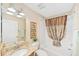 Bathroom with granite countertop, decorative mirror and shower-tub combination at 3041 Batally Ct, The Villages, FL 32162