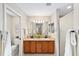 Well-lit bathroom features dual sinks, wood cabinetry, and tile floors at 3041 Batally Ct, The Villages, FL 32162