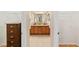 Bathroom featuring dual sinks, a wooden cabinet, and open closet space at 3041 Batally Ct, The Villages, FL 32162