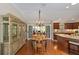 Open-concept dining room area with hardwood floors and a view to the kitchen and outside patio at 3041 Batally Ct, The Villages, FL 32162
